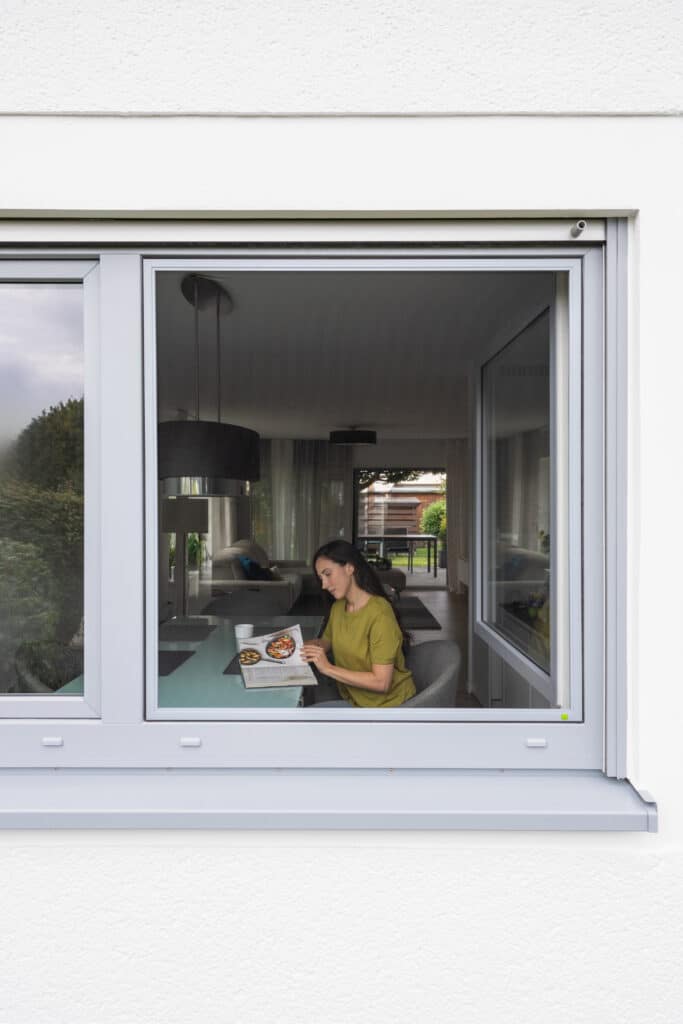 Maßgefertigter Fliegengitter-Spannrahmen in Mannheim an einem Fenster mit Blick in den Wohnbereich